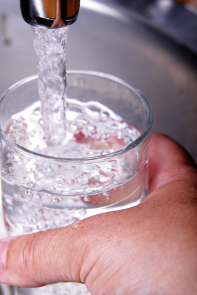 Trinkwasser wird aus dem Hahn in ein Glas gefüllt