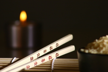 Chinesische Essstäbchen, im Hintergrund Reis