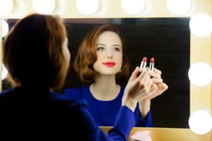 Frau schminkt sich am Hollywoodspiegel